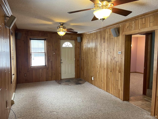 foyer entrance with light carpet, crown molding, and a textured ceiling