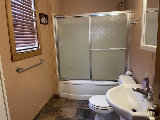 full bathroom with toilet, shower / bath combination with glass door, and sink