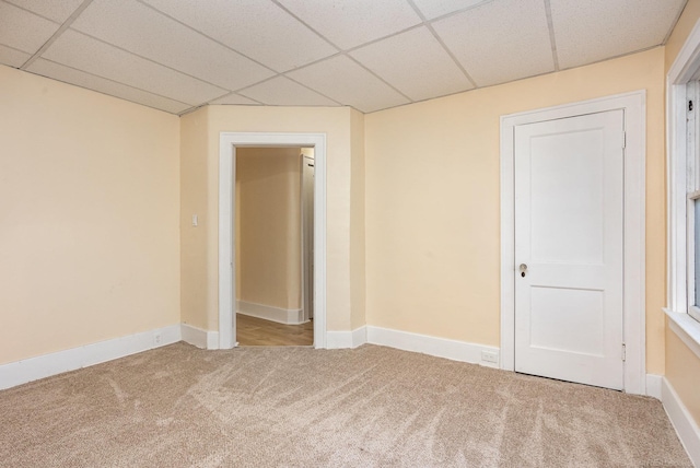 carpeted spare room with a paneled ceiling