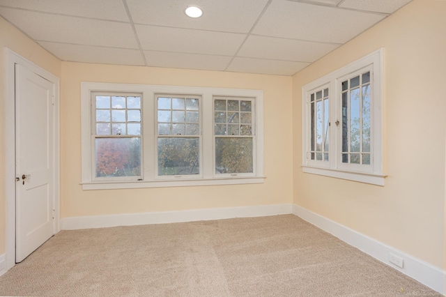 empty room with a paneled ceiling and carpet flooring