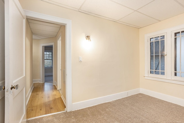 empty room with carpet flooring and a paneled ceiling