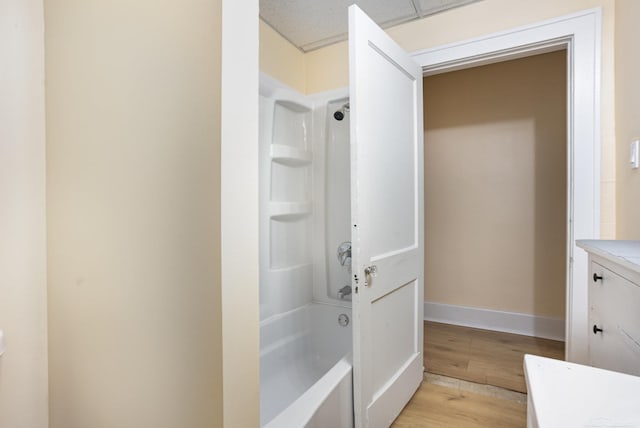 bathroom featuring hardwood / wood-style flooring, vanity, and bathing tub / shower combination