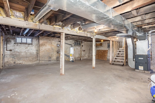 basement featuring gas water heater, heating unit, and electric panel