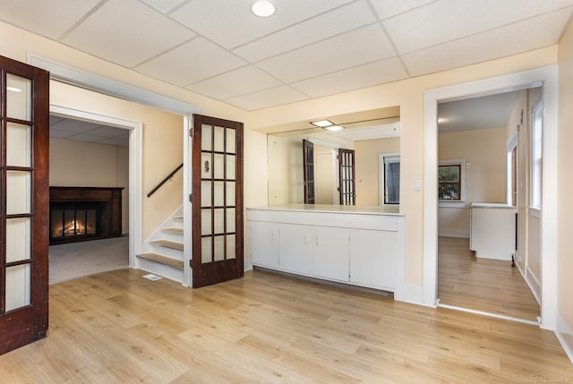 empty room with light hardwood / wood-style flooring and a paneled ceiling