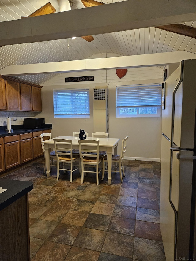 dining area featuring vaulted ceiling with beams, wood ceiling, and plenty of natural light