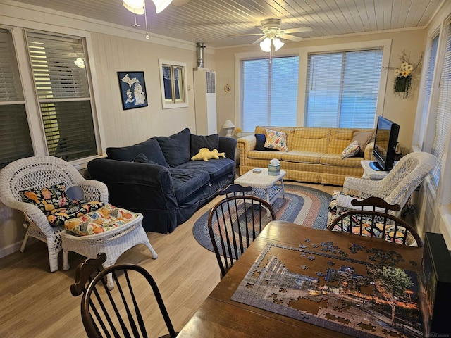 living room featuring wood-type flooring, ornamental molding, and ceiling fan