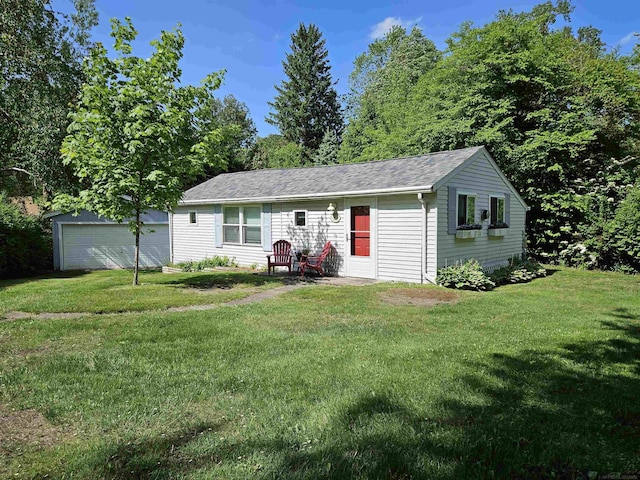 view of front of home with a garage, an outdoor structure, and a front yard