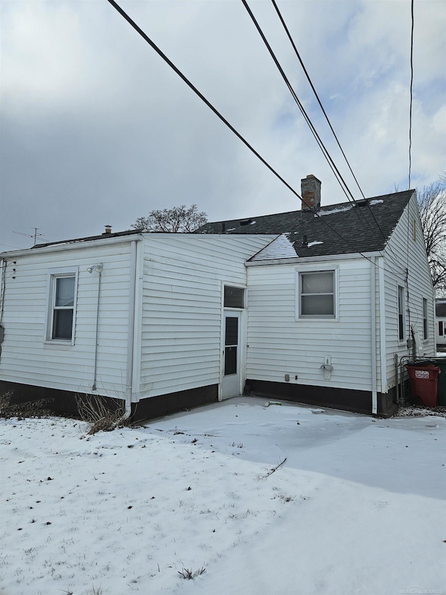 view of snow covered rear of property