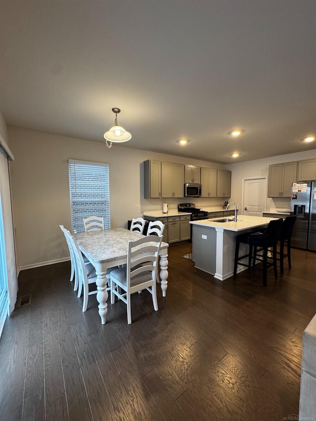 dining space featuring sink and dark wood-type flooring