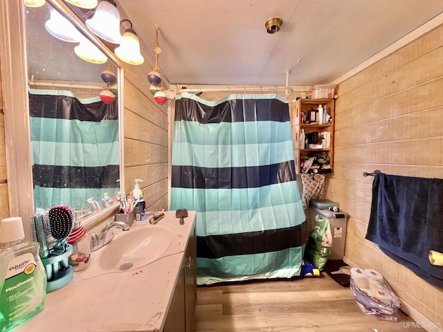 bathroom with walk in shower, vanity, wooden walls, and hardwood / wood-style floors