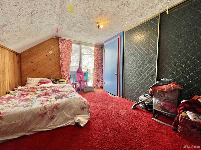 carpeted bedroom with lofted ceiling, wooden walls, and a textured ceiling