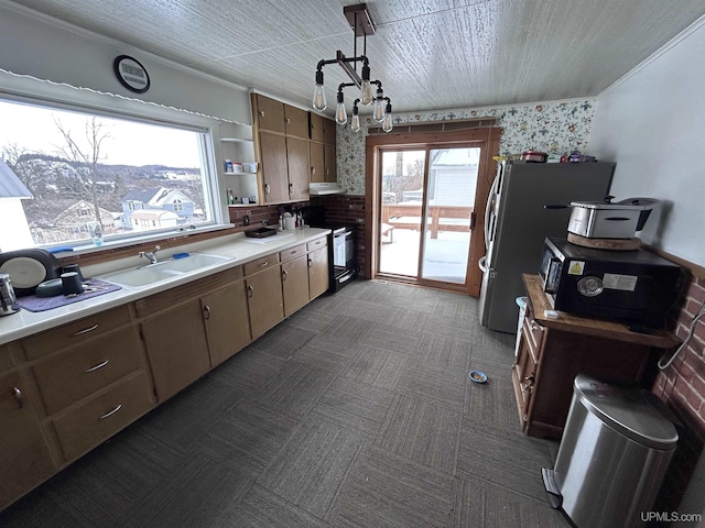 kitchen with sink, stainless steel fridge, an inviting chandelier, ornamental molding, and black / electric stove