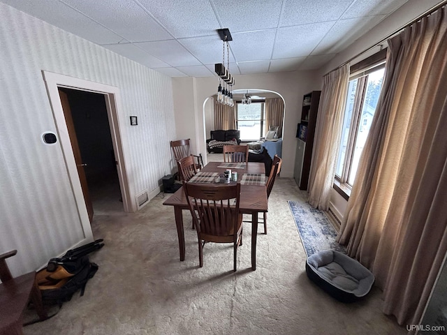 carpeted dining room with a paneled ceiling