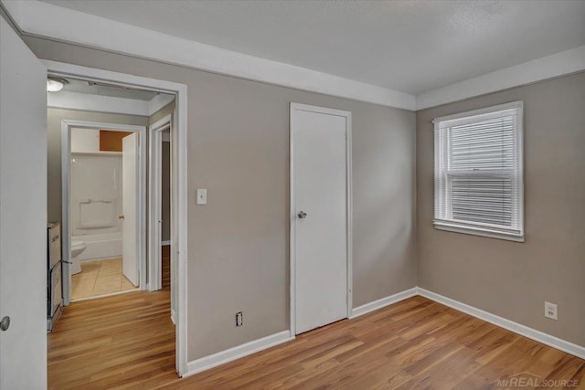 unfurnished bedroom with a closet and light hardwood / wood-style flooring