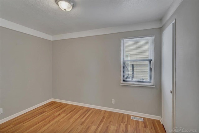 unfurnished room with hardwood / wood-style floors and a textured ceiling