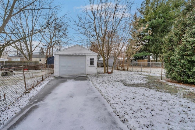 yard layered in snow with a garage and an outdoor structure