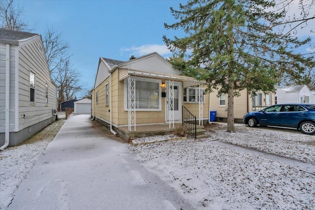 bungalow-style home with a garage and an outbuilding