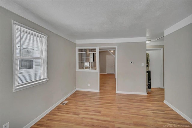 spare room with light hardwood / wood-style flooring and a textured ceiling