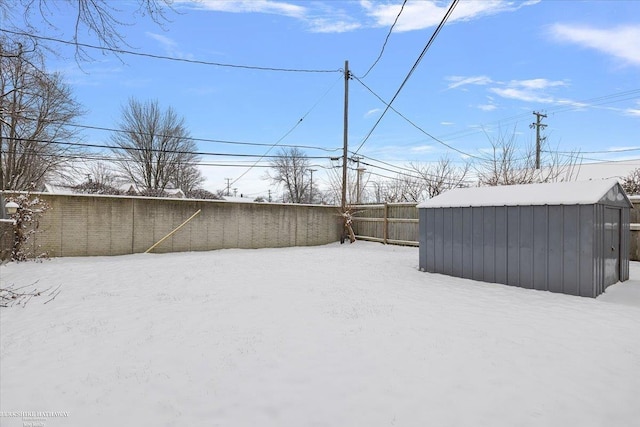 yard covered in snow with a storage shed