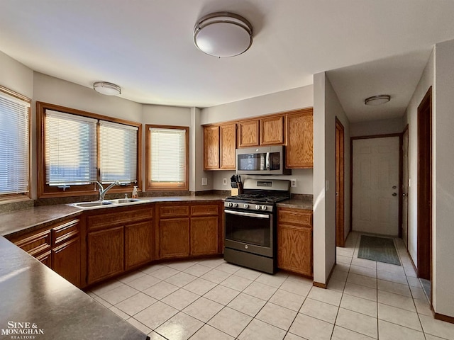 kitchen featuring stainless steel appliances, sink, and light tile patterned floors