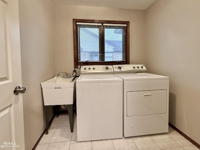 laundry room with light tile patterned flooring, independent washer and dryer, and sink