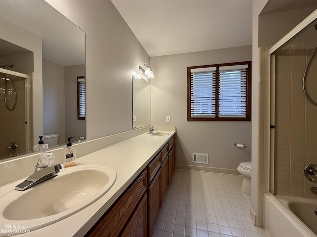 full bathroom featuring vanity, tiled shower / bath combo, tile patterned floors, and toilet