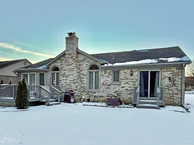 view of snow covered rear of property