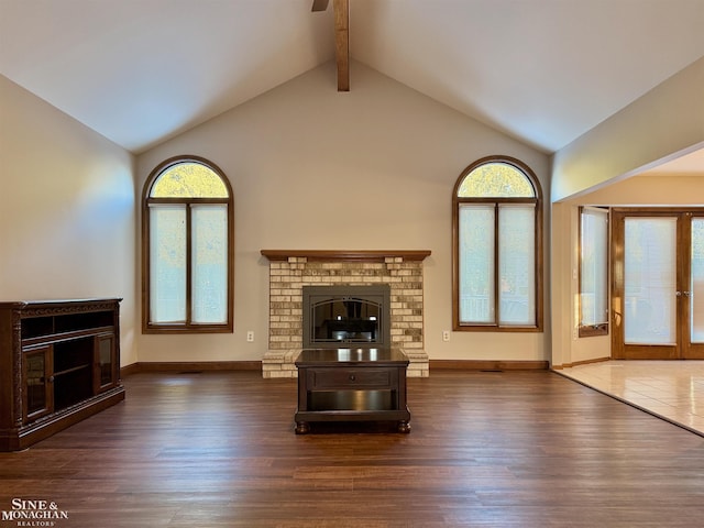 unfurnished living room featuring beamed ceiling, a fireplace, dark hardwood / wood-style flooring, and high vaulted ceiling