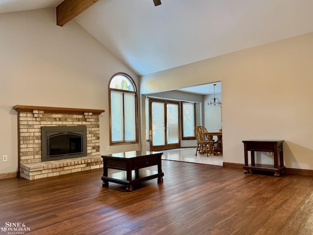 living room featuring beamed ceiling, high vaulted ceiling, hardwood / wood-style floors, and a brick fireplace