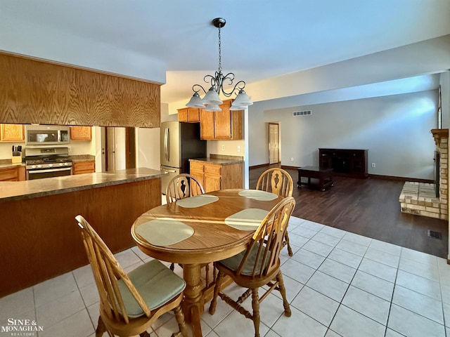 dining area featuring light tile patterned floors and an inviting chandelier