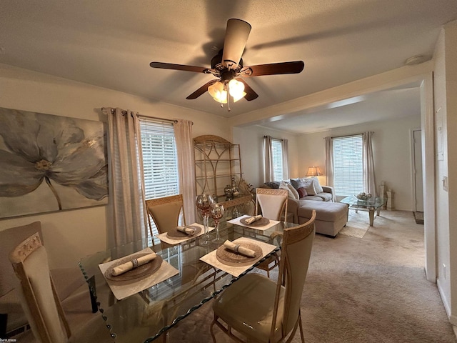 dining space with light colored carpet and ceiling fan