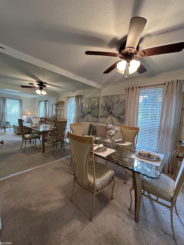 dining space with ceiling fan, carpet floors, and a textured ceiling