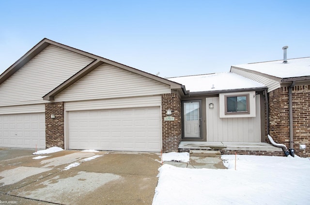 view of front facade featuring driveway, an attached garage, and brick siding