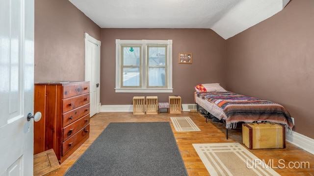 bedroom featuring wood-type flooring and lofted ceiling