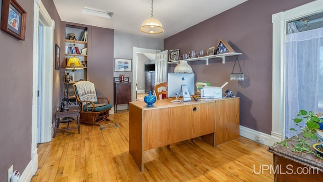 home office with light hardwood / wood-style flooring