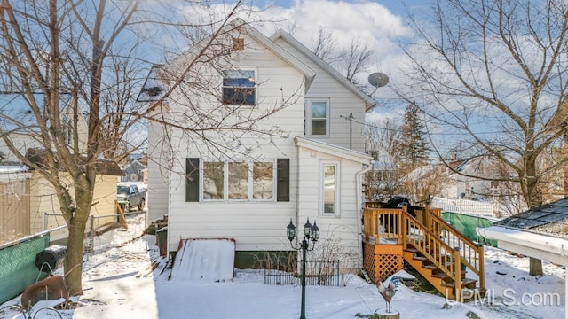 view of snow covered back of property