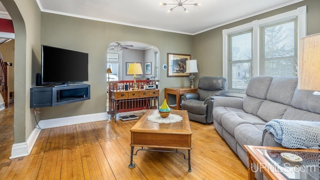 living room with a notable chandelier, crown molding, and light hardwood / wood-style flooring