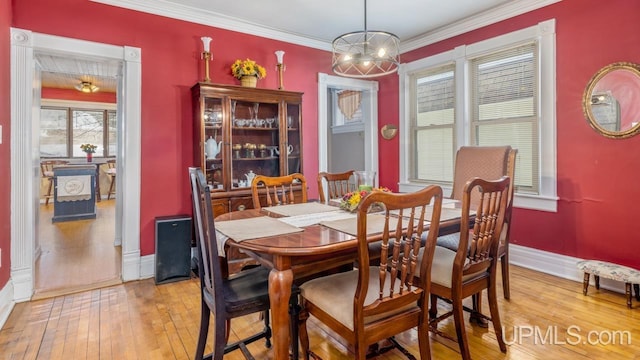 dining space featuring an inviting chandelier, crown molding, and light hardwood / wood-style floors