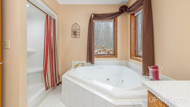 bathroom with vanity, tile patterned flooring, and tiled tub