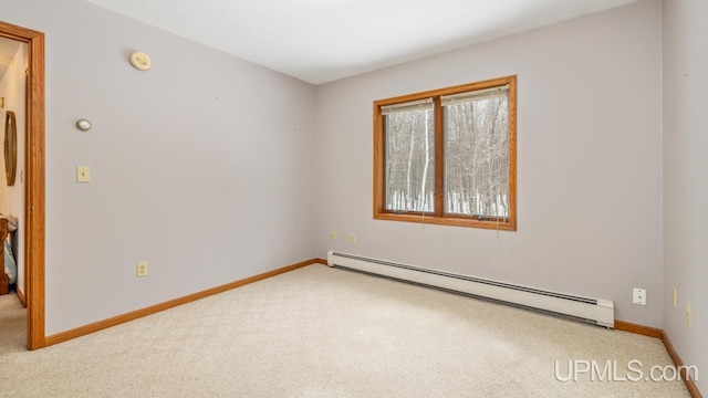 carpeted empty room featuring a baseboard heating unit