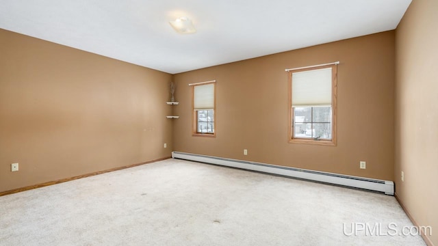 carpeted spare room with a baseboard radiator and a wealth of natural light