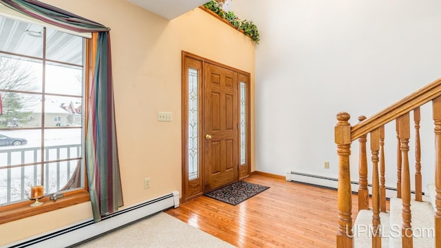 foyer featuring baseboard heating and light hardwood / wood-style flooring