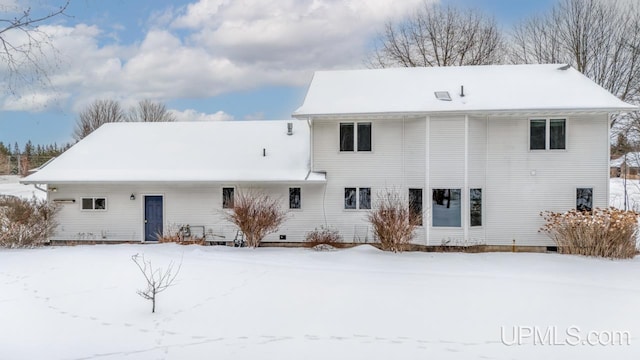 view of snow covered back of property