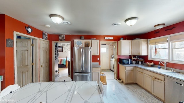 kitchen featuring stainless steel appliances, sink, light wood-type flooring, and washer / clothes dryer