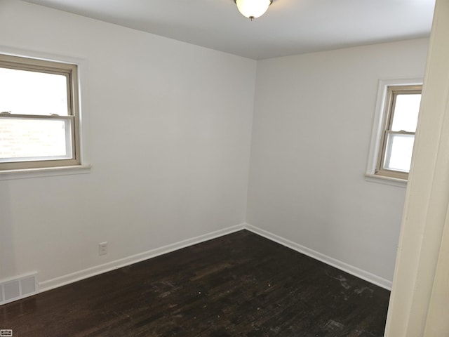 spare room with dark hardwood / wood-style flooring