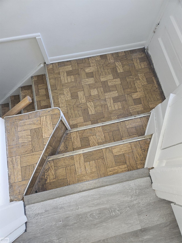 stairway featuring parquet flooring