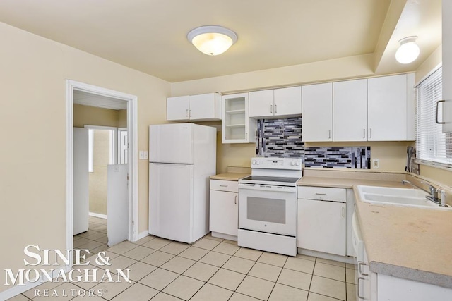 kitchen with white cabinetry, sink, white appliances, and light tile patterned flooring