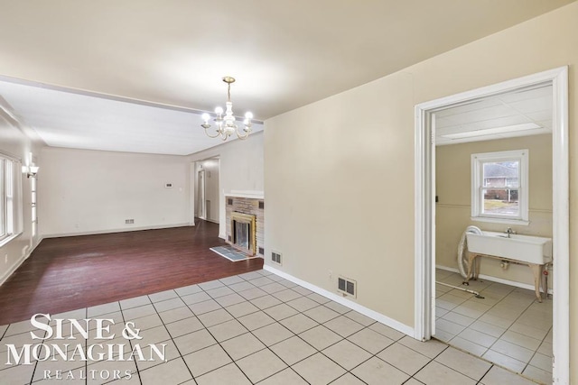 unfurnished living room featuring light tile patterned floors and an inviting chandelier