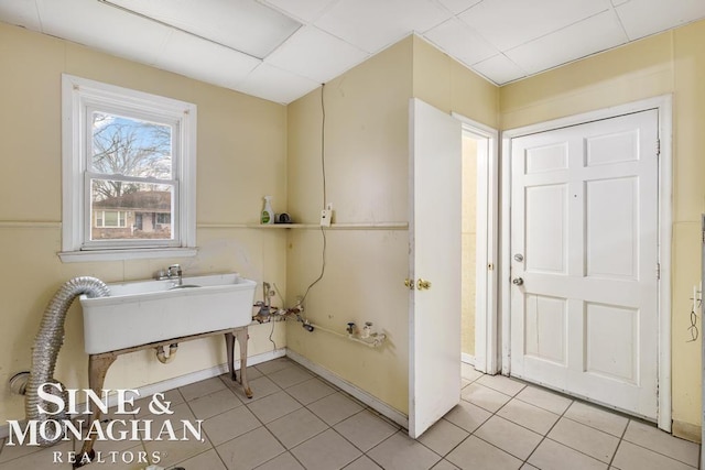 bathroom featuring tile patterned floors, sink, and a drop ceiling