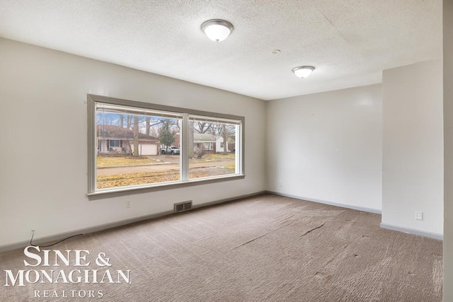 unfurnished room with carpet floors and a textured ceiling